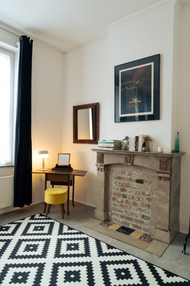 Cheminée et bureau dans le séjour de l'appartement Lyves 2, situé au 1er étage du 50 Rue Dossin (4000) en Belgique