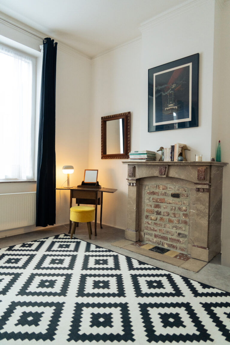 Cheminée et bureau dans le séjour de l'appartement Lyves 2, situé au 1er étage du 50 Rue Dossin à Liège (4000) en Belgique